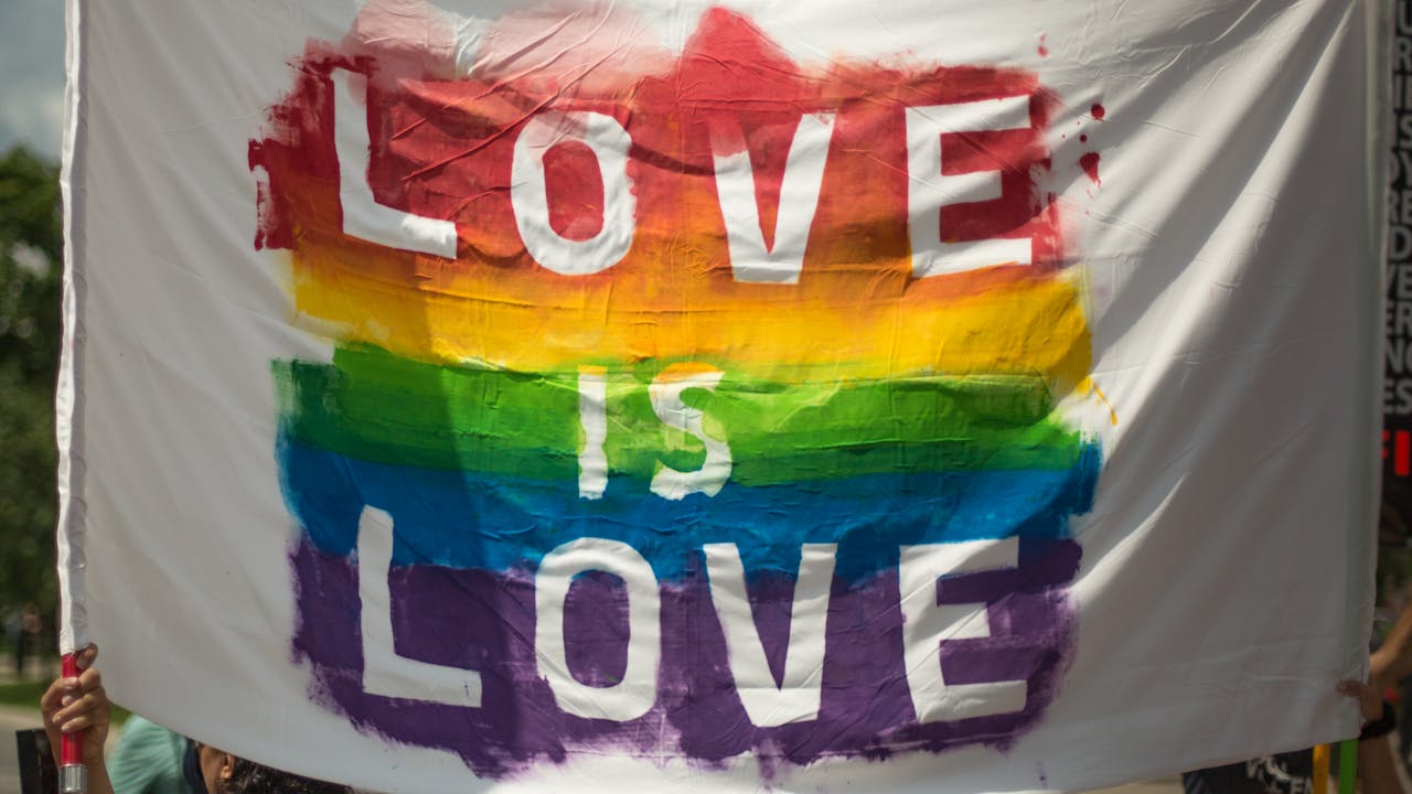 Colorful Love is Love pride banner at a parade in London, Ontario celebrating equality and diversity.